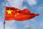 Pastor protestante é detido na China por atividades religiosas não autorizadas 4 Bandeira da China acenando em um mastro em um ceu azul Foto Canva Pro
