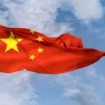 Pastor protestante é detido na China por atividades religiosas não autorizadas 3 Bandeira da China acenando em um mastro em um ceu azul Foto Canva Pro