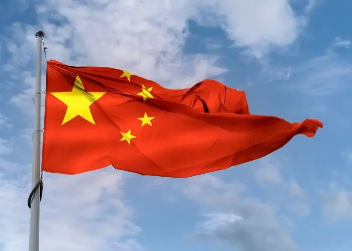 Pastor protestante é detido na China por atividades religiosas não autorizadas 1 Bandeira da China acenando em um mastro em um ceu azul Foto Canva Pro
