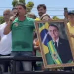 Flávio Bolsonaro reafirma que pai, Jair Bolsonaro, entregará faixa presidencial se for eleito 3 Flavio Bolsonaro segura quadro de Jair Bolsonaro